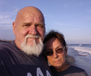 A couple on respite at the beach sponsored by A Week Away.