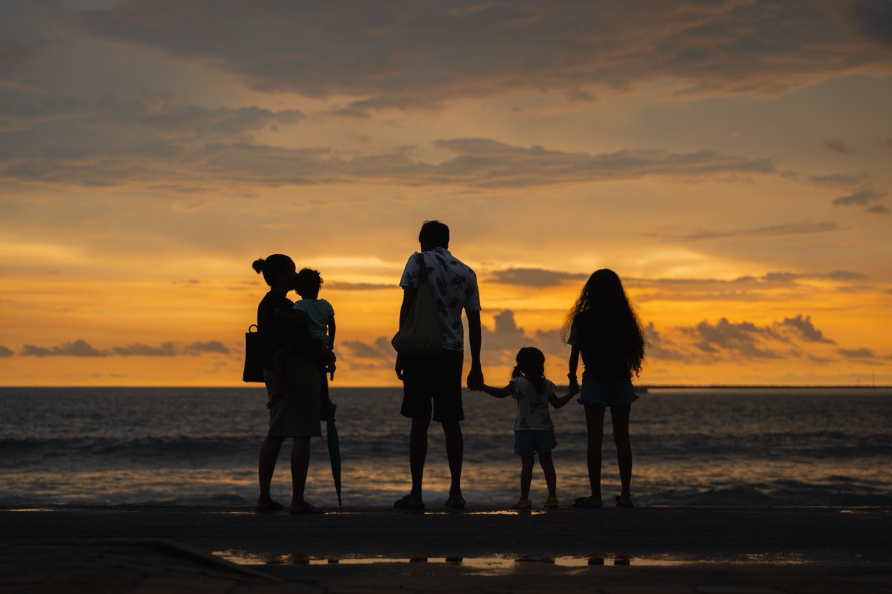 A family together at the beach during sunset..